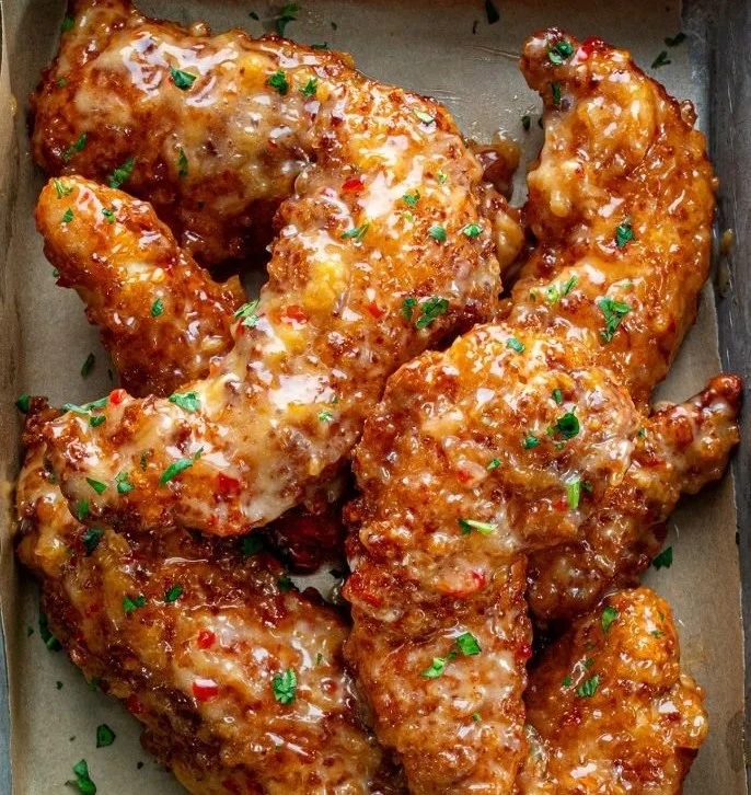 Delicious plate of Bang Bang Chicken garnished with fresh herbs.