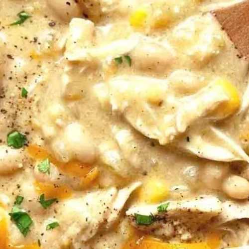 Bowl of white chicken chili garnished with cilantro and jalapenos