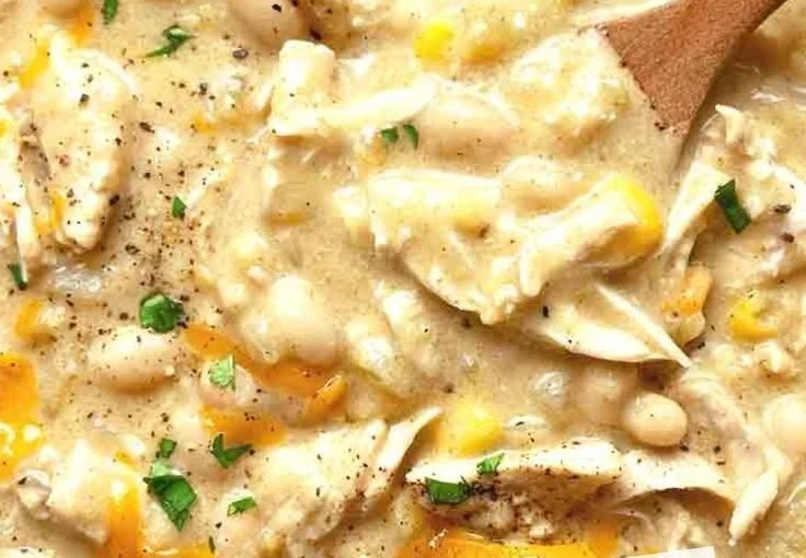 Bowl of white chicken chili garnished with cilantro and jalapenos